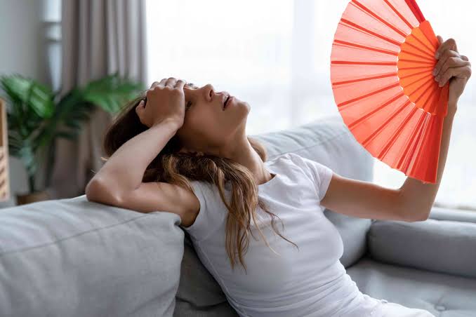 Homeowner fanning themselves during a heat wave
